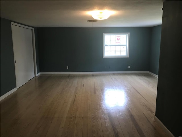 unfurnished room featuring baseboards and wood finished floors