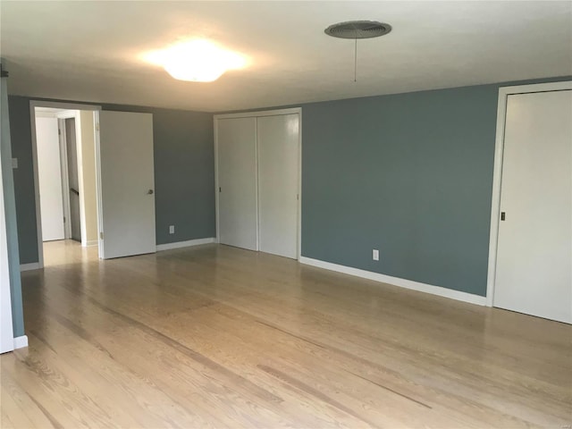 empty room with baseboards and light wood-style floors