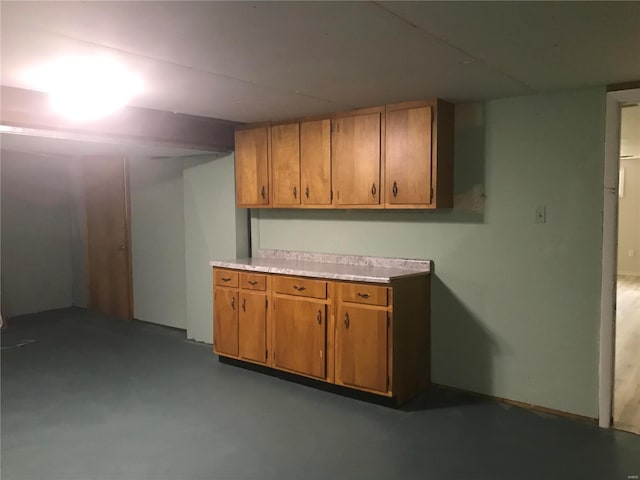 interior space featuring light countertops, brown cabinetry, and finished concrete floors