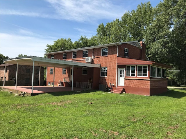 rear view of property with entry steps, a patio, brick siding, and a yard