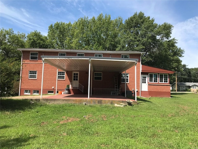 rear view of house with entry steps, an attached carport, a lawn, and brick siding