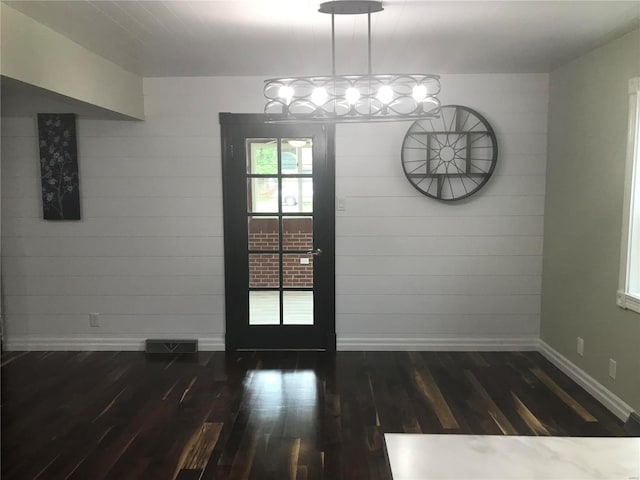 unfurnished dining area featuring dark wood-style floors, visible vents, and baseboards