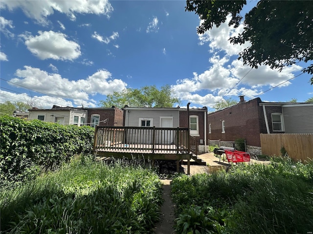 rear view of property featuring a wooden deck