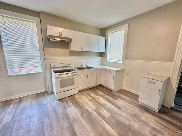 kitchen with white cabinets, light hardwood / wood-style flooring, white electric stove, and sink