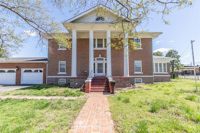 greek revival house with a front yard and a garage