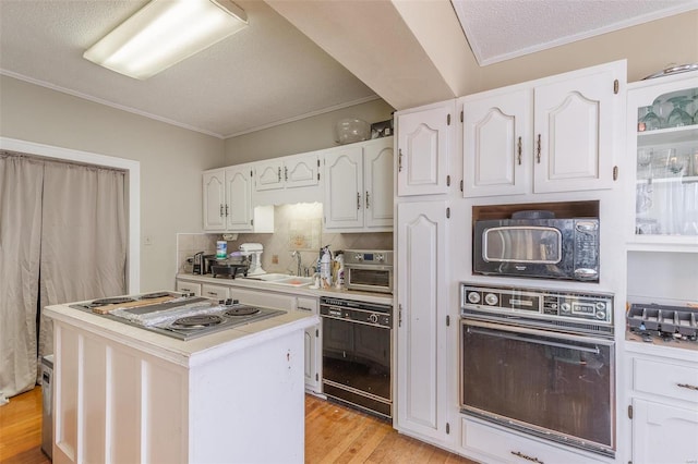 kitchen with a center island, light hardwood / wood-style floors, white cabinetry, and black appliances