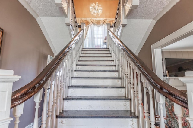 staircase featuring lofted ceiling, a textured ceiling, and a notable chandelier