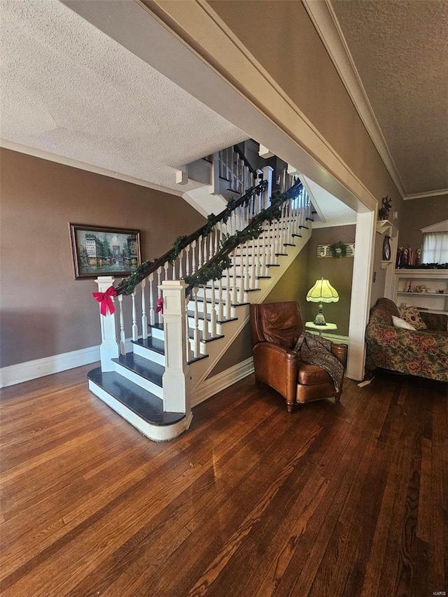 staircase featuring lofted ceiling, crown molding, hardwood / wood-style floors, and a textured ceiling