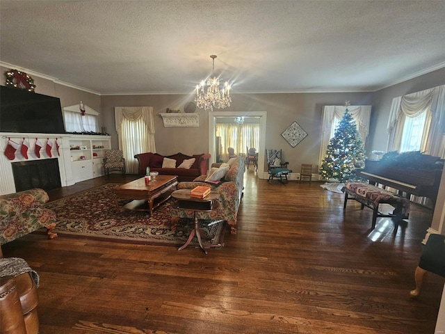 living room with dark hardwood / wood-style flooring, ornamental molding, a textured ceiling, and a chandelier