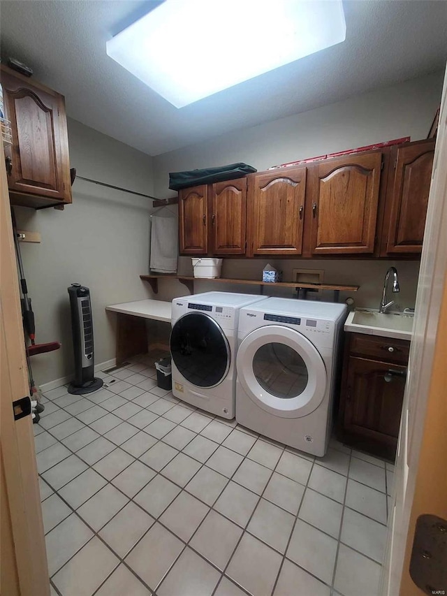 clothes washing area with hookup for a washing machine, light tile floors, sink, separate washer and dryer, and cabinets