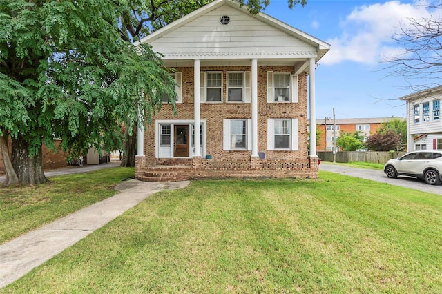 view of front of house with covered porch and a front yard