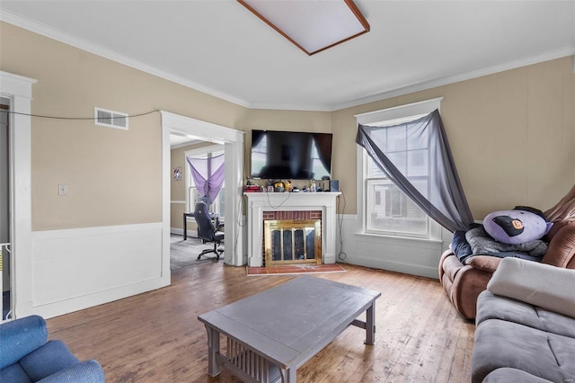 living room featuring a fireplace, crown molding, and hardwood / wood-style floors