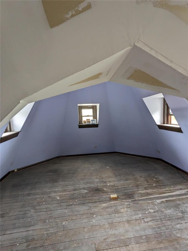 bonus room with vaulted ceiling and wood-type flooring