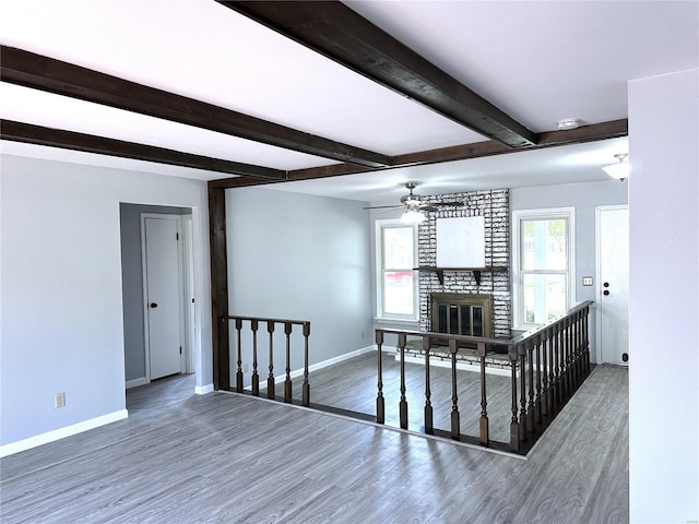 interior space featuring dark hardwood / wood-style floors, a brick fireplace, and ceiling fan