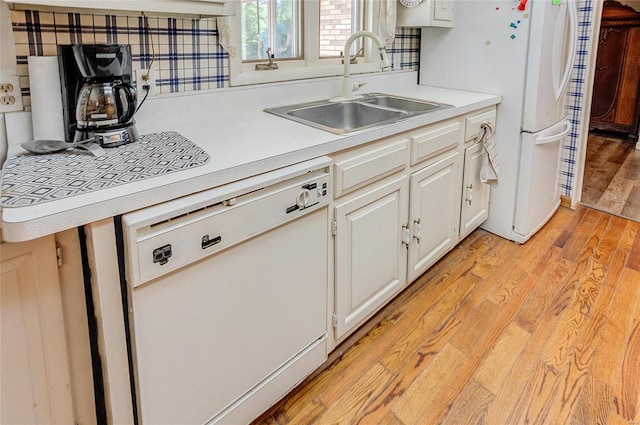 kitchen featuring white appliances, sink, light hardwood / wood-style flooring, and white cabinets