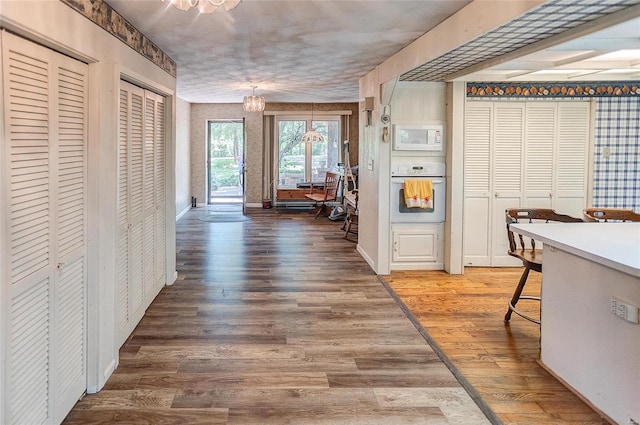 hallway featuring wood-type flooring and a chandelier