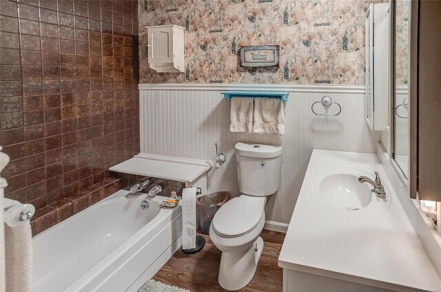 full bathroom featuring hardwood / wood-style flooring, tiled shower / bath, vanity, and toilet