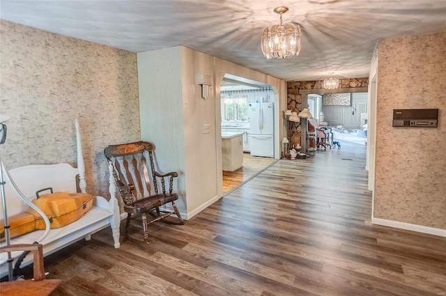 living area with an inviting chandelier and dark hardwood / wood-style flooring