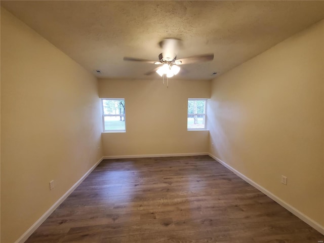 empty room featuring wood-type flooring, plenty of natural light, and ceiling fan