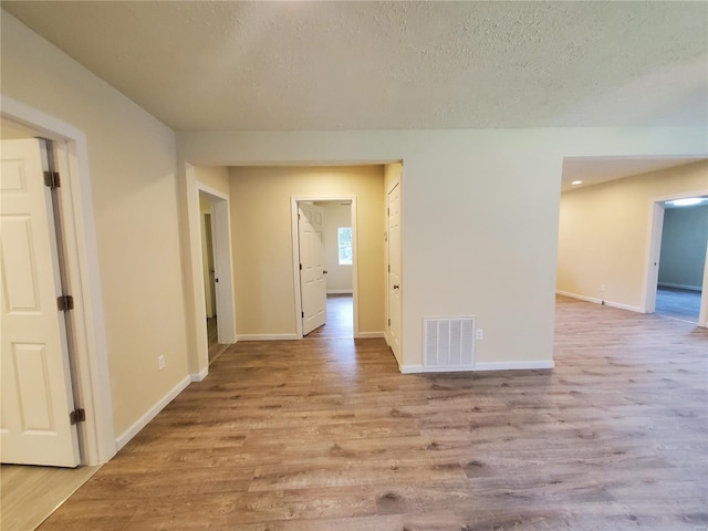 unfurnished room with a textured ceiling and hardwood / wood-style flooring