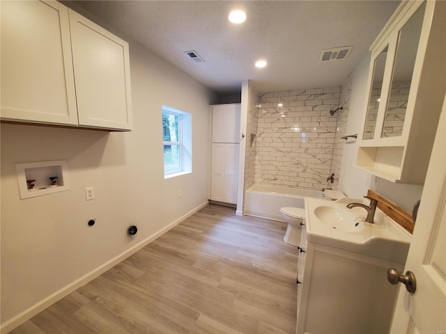 full bathroom featuring tiled shower / bath, hardwood / wood-style flooring, toilet, and vanity