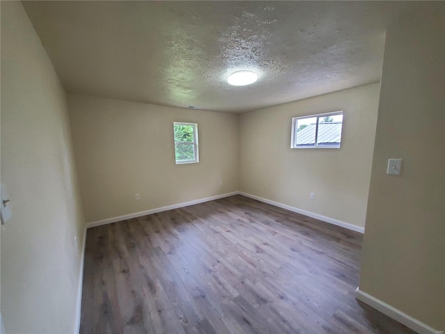 unfurnished room featuring a textured ceiling and wood-type flooring