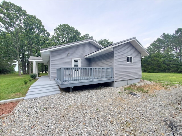 rear view of property featuring a wooden deck and a lawn