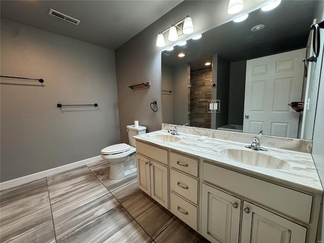 bathroom featuring walk in shower, vanity, and toilet