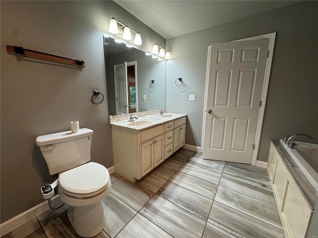 bathroom featuring vanity, a textured ceiling, a tub, and toilet