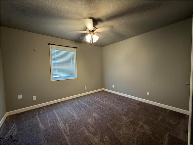 empty room featuring dark colored carpet, a textured ceiling, and ceiling fan