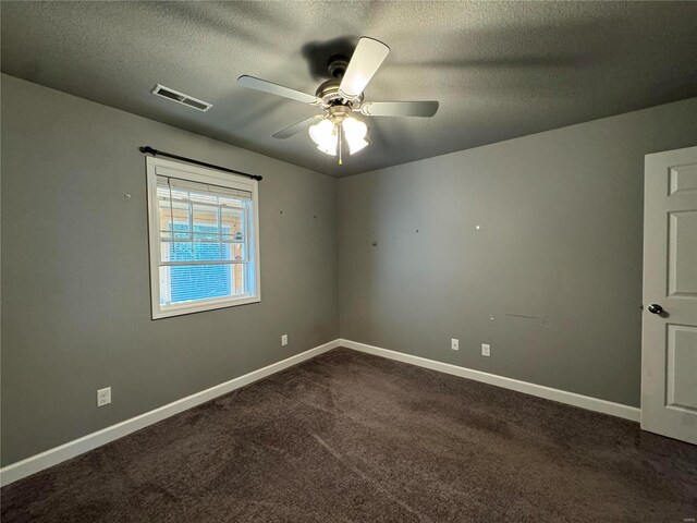 carpeted spare room featuring ceiling fan and a textured ceiling