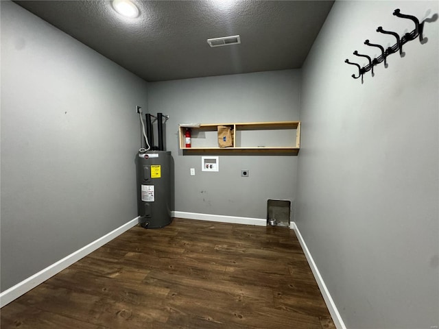 laundry area with electric dryer hookup, hookup for a washing machine, dark hardwood / wood-style floors, electric water heater, and a textured ceiling