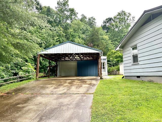 garage featuring a yard and a carport