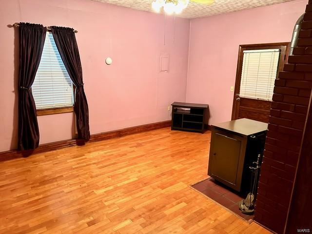 unfurnished room with ceiling fan, light hardwood / wood-style floors, and a textured ceiling