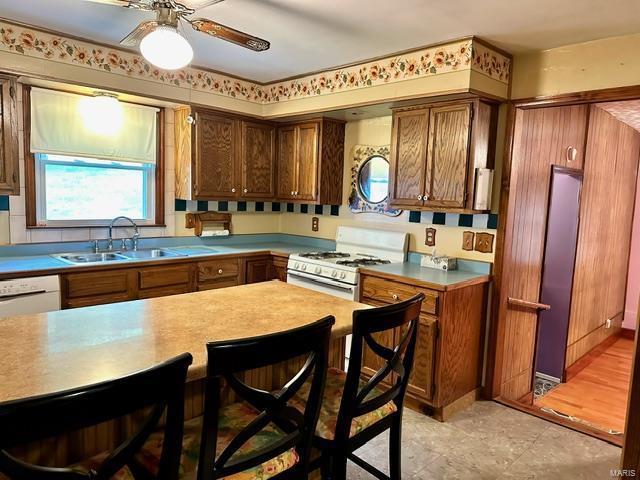 kitchen with white appliances, light hardwood / wood-style floors, ceiling fan, and sink