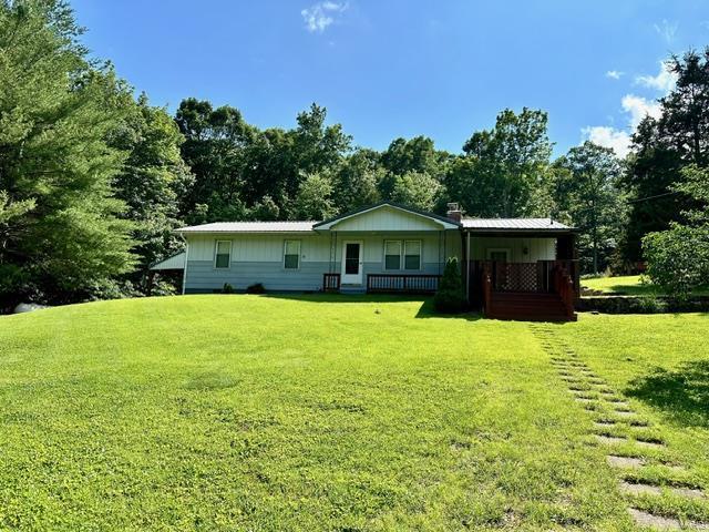 back of property with a porch and a yard