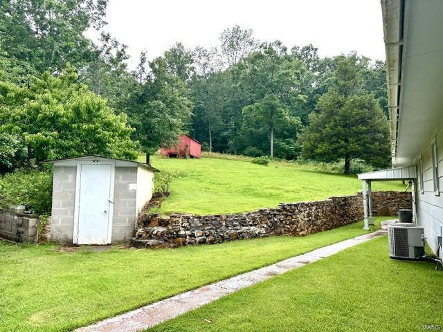 view of yard with a shed and central AC