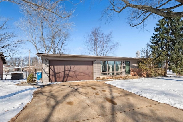 mid-century modern home featuring driveway and an attached garage