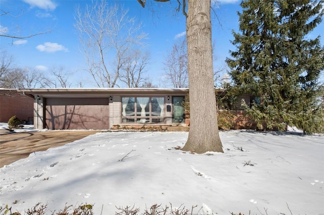 snow covered house with a garage