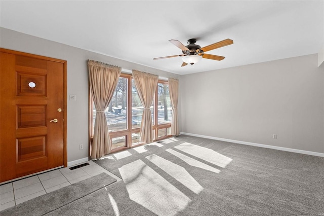 interior space with light tile patterned flooring, baseboards, visible vents, and light colored carpet