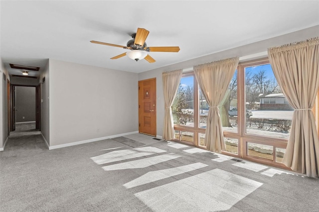 empty room with light carpet, ceiling fan, visible vents, and baseboards