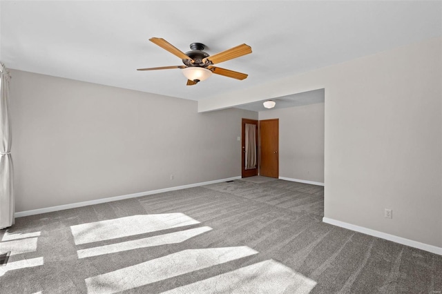 unfurnished room with carpet, baseboards, and a ceiling fan