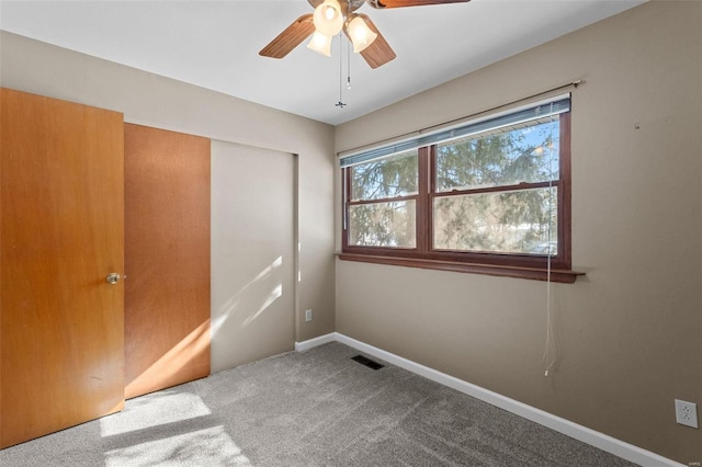 unfurnished bedroom with baseboards, visible vents, a ceiling fan, carpet floors, and a closet