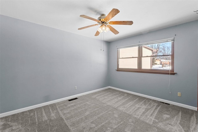 carpeted empty room with baseboards, visible vents, and ceiling fan