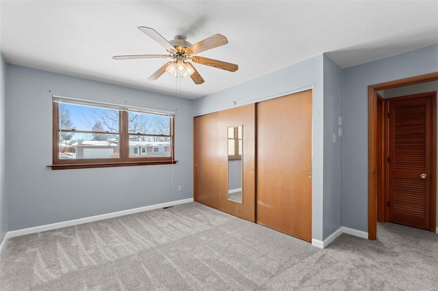 unfurnished bedroom with light carpet, a closet, and baseboards