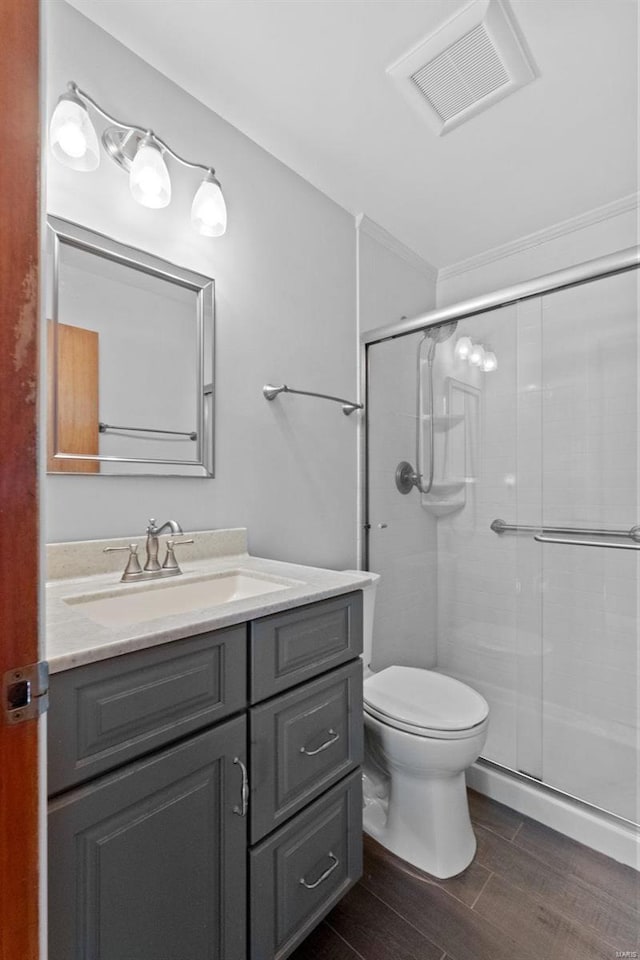 bathroom featuring visible vents, toilet, a stall shower, vanity, and wood finished floors