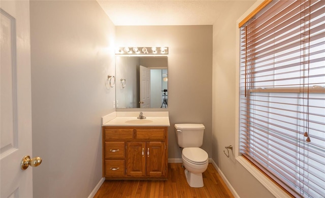 bathroom featuring toilet, hardwood / wood-style flooring, and vanity