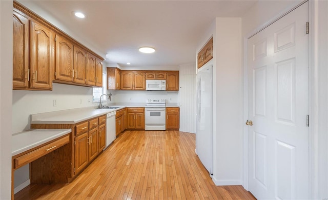 kitchen featuring sink, white appliances, and light hardwood / wood-style floors