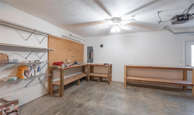 basement with electric panel, a textured ceiling, a workshop area, and ceiling fan