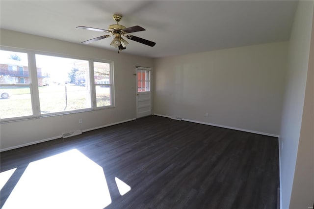 empty room with ceiling fan and dark hardwood / wood-style flooring